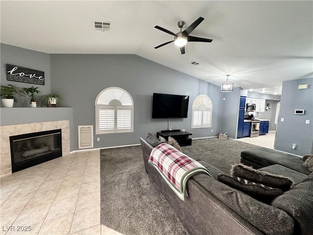 living area with lofted ceiling, light tile patterned floors, a fireplace, and visible vents