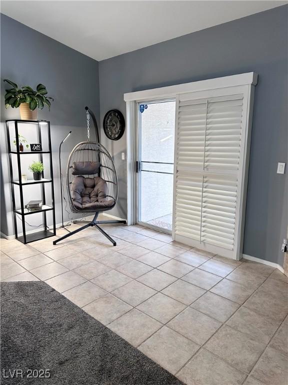 interior space featuring baseboards and light tile patterned flooring