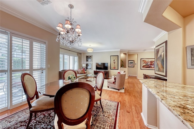 dining room featuring light hardwood / wood-style flooring, a notable chandelier, and ornamental molding