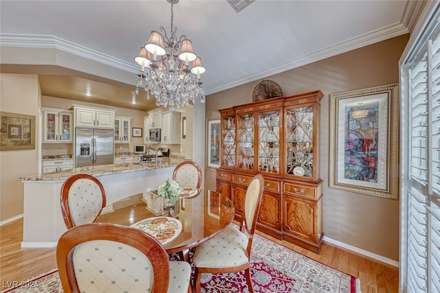 dining area featuring a chandelier, light hardwood / wood-style flooring, and crown molding