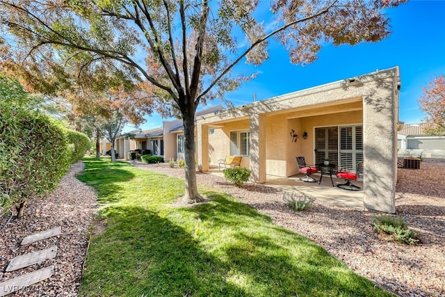 back of property featuring a lawn, central AC unit, and a patio