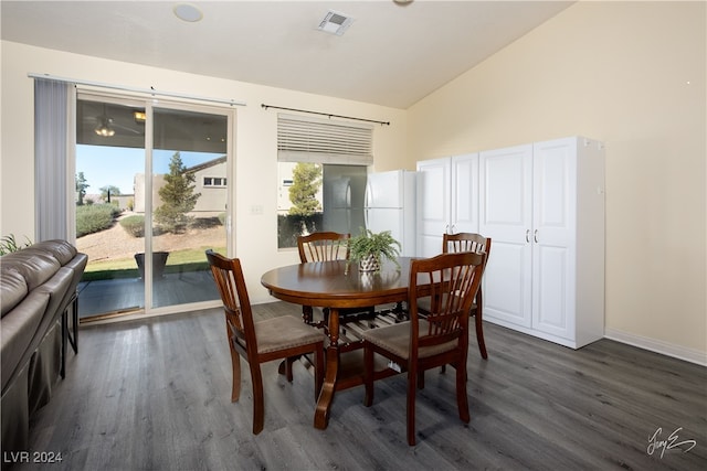 dining area featuring high vaulted ceiling and dark hardwood / wood-style floors