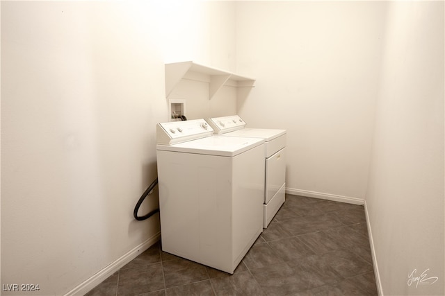 laundry area featuring washing machine and clothes dryer and dark tile patterned floors