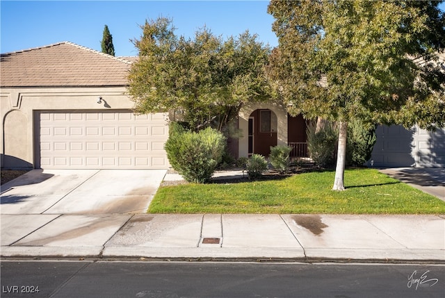 obstructed view of property with a garage and a front yard