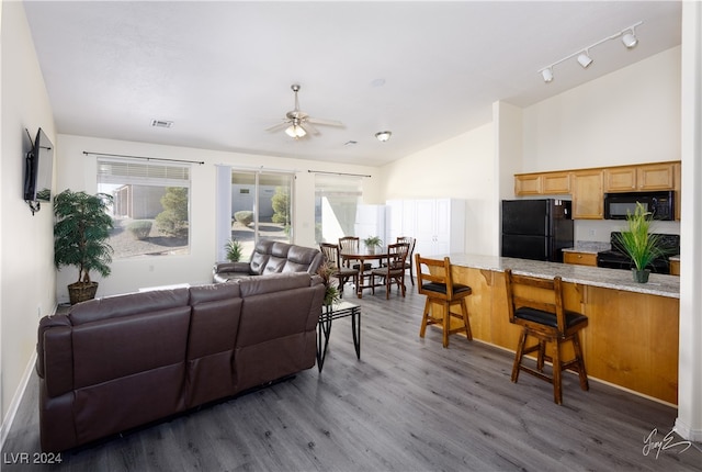 living room featuring ceiling fan, dark wood-type flooring, and lofted ceiling