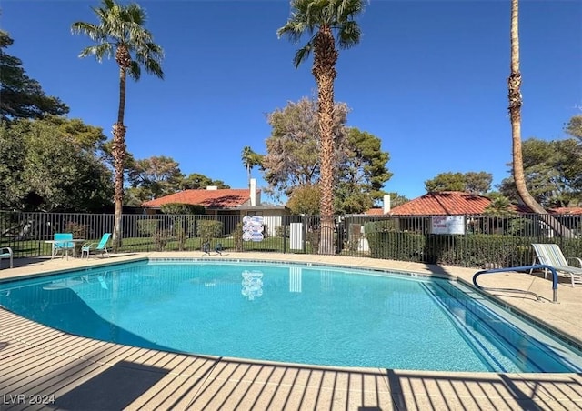 community pool featuring fence and a patio