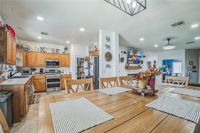 dining space featuring light tile patterned floors, ceiling fan, a healthy amount of sunlight, and sink