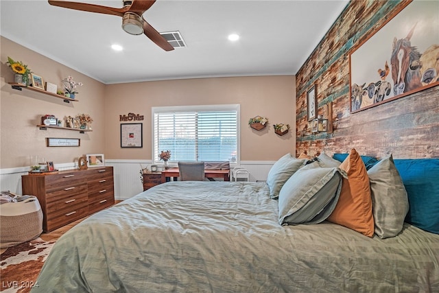 bedroom with ceiling fan, crown molding, and wooden walls