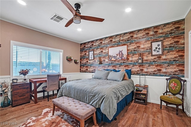 bedroom featuring light wood-type flooring, ceiling fan, and wood walls