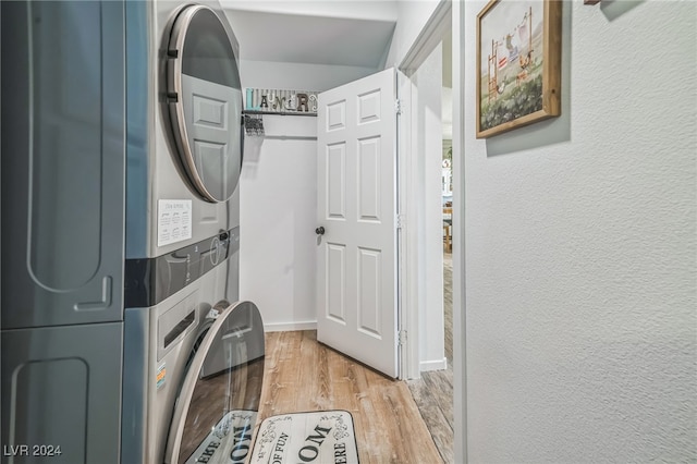 clothes washing area with light wood-type flooring and stacked washing maching and dryer