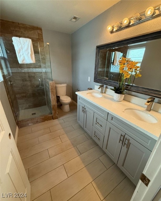 bathroom with an enclosed shower, vanity, and toilet