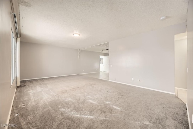 carpeted spare room with a textured ceiling