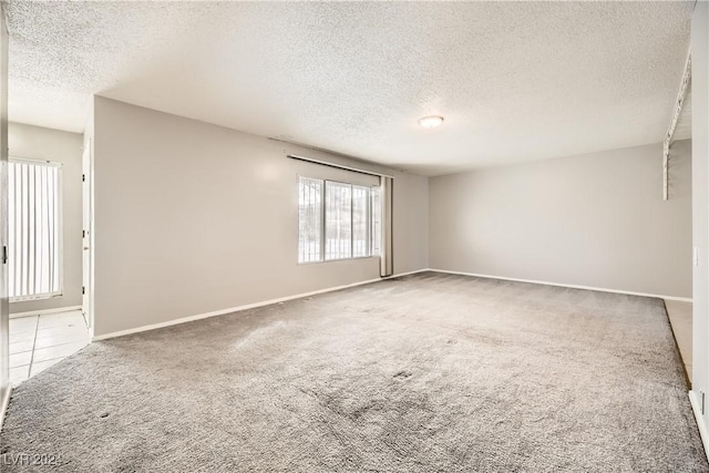 carpeted spare room with a textured ceiling