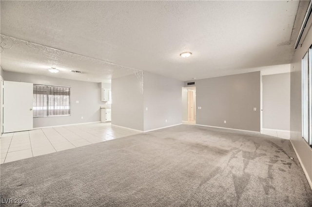 carpeted spare room with a textured ceiling