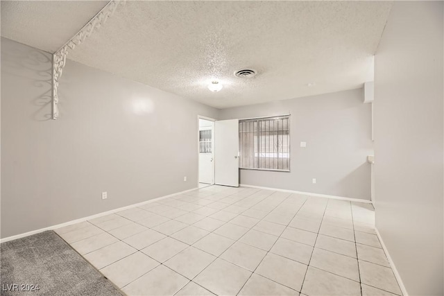 tiled spare room featuring a textured ceiling