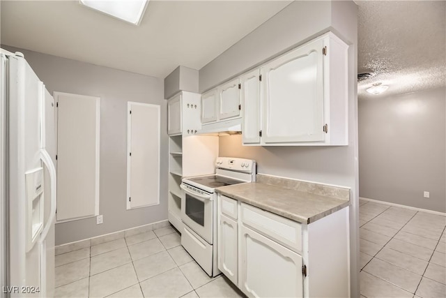 kitchen featuring light tile patterned floors, white cabinets, and white appliances