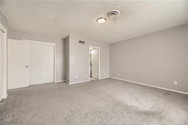 unfurnished bedroom with carpet, a textured ceiling, and a closet