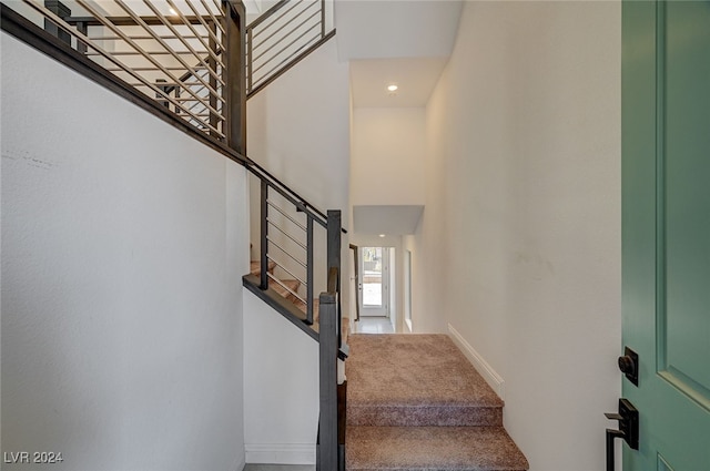 staircase featuring a towering ceiling