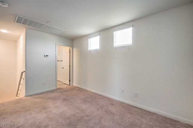 spare room featuring light carpet