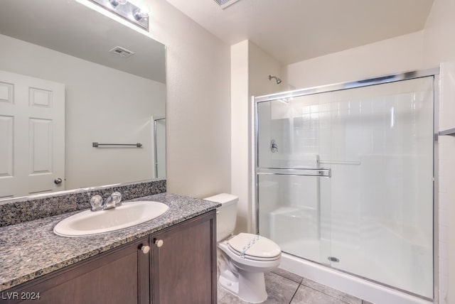 bathroom with tile patterned floors, vanity, toilet, and a shower with door