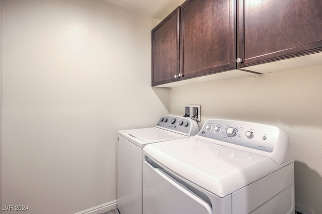 laundry room featuring washing machine and clothes dryer and cabinets