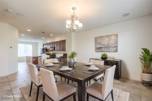 tiled dining room with a notable chandelier