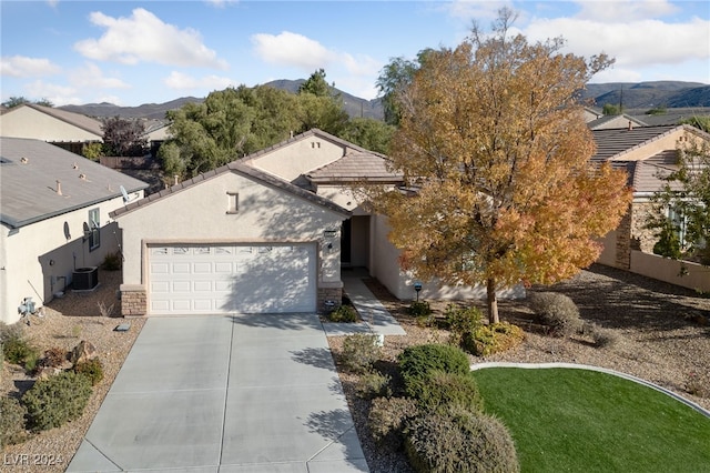 view of front of home with a mountain view, a garage, and cooling unit