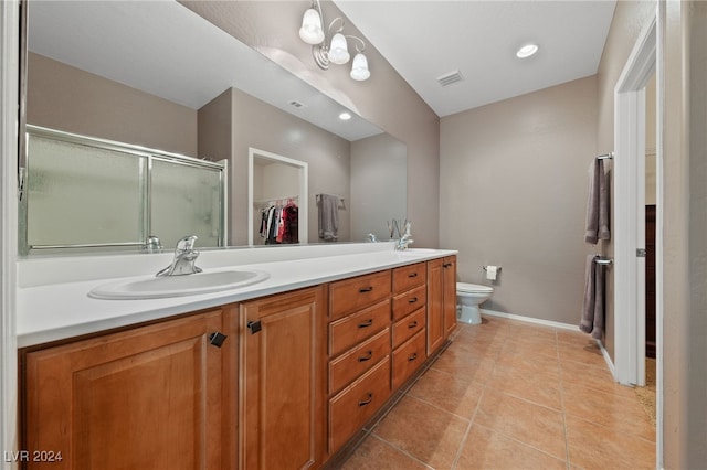 bathroom featuring tile patterned floors, vanity, an enclosed shower, and toilet