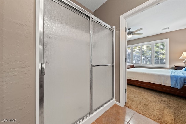 bathroom with tile patterned floors, ceiling fan, and a shower with shower door