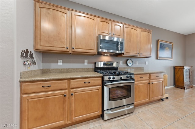 kitchen featuring light tile patterned flooring and stainless steel appliances