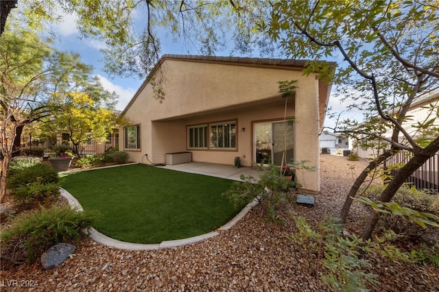 back of property with a patio and a lawn