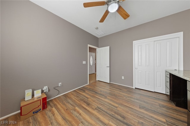 unfurnished bedroom featuring ceiling fan, dark hardwood / wood-style flooring, and a closet