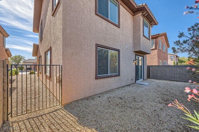 62 Augusta Course Ave, Las Vegas, NV 89148 - view of property exterior featuring stucco siding, a fenced backyard, and a gate