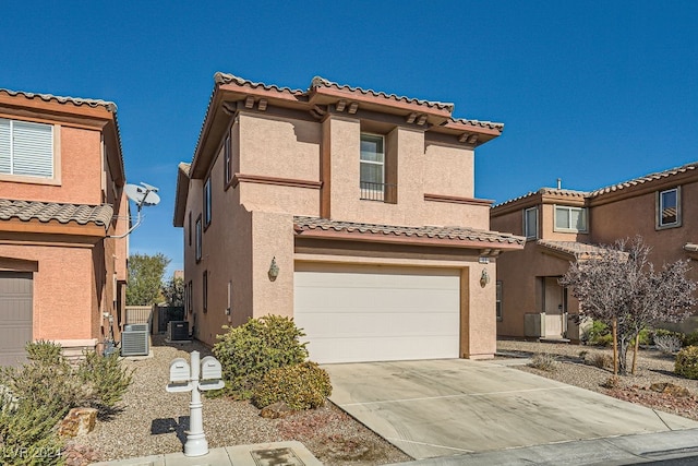 mediterranean / spanish-style house featuring a garage and central AC unit