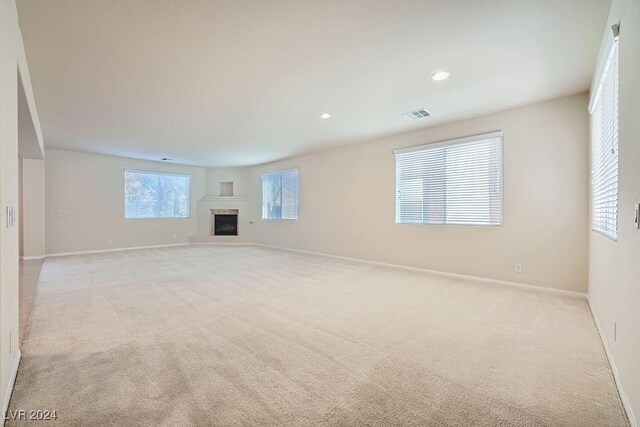 62 Augusta Course Ave, Las Vegas, NV 89148 - unfurnished living room featuring light colored carpet, a fireplace with raised hearth, and recessed lighting