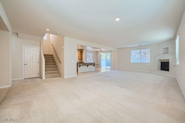 62 Augusta Course Ave, Las Vegas, NV 89148 - unfurnished living room featuring light carpet, stairway, a high end fireplace, and recessed lighting