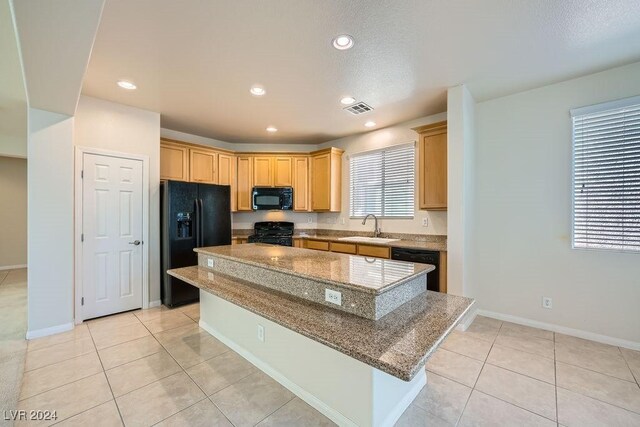 62 Augusta Course Ave, Las Vegas, NV 89148 - kitchen with black appliances, a center island, light tile patterned floors, stone countertops, and recessed lighting