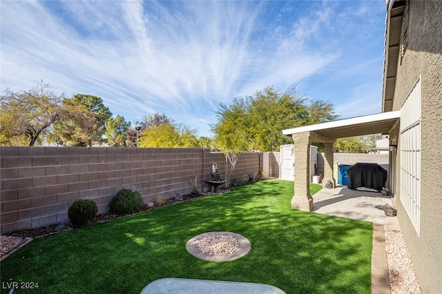 view of yard featuring a storage unit and a patio