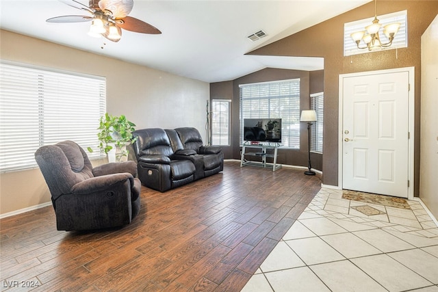 living room featuring ceiling fan with notable chandelier and lofted ceiling