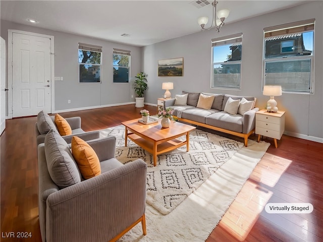 living room featuring wood-type flooring, an inviting chandelier, and a wealth of natural light