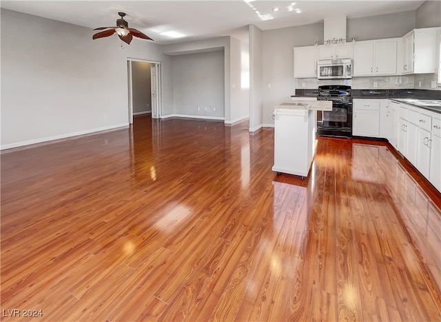 kitchen featuring white cabinets, decorative backsplash, ceiling fan, light hardwood / wood-style floors, and gas stove