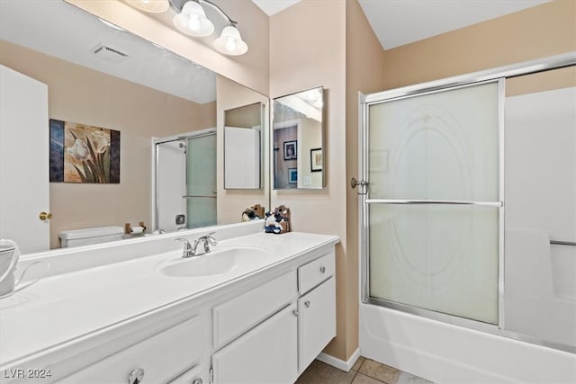 full bathroom featuring toilet, vanity, tile patterned floors, and enclosed tub / shower combo