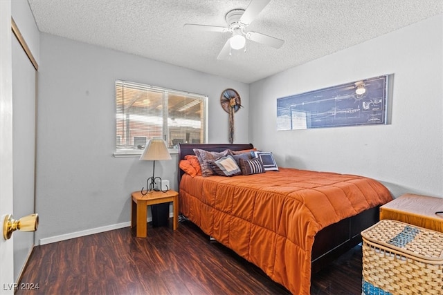 bedroom with ceiling fan, dark hardwood / wood-style flooring, a textured ceiling, and multiple windows