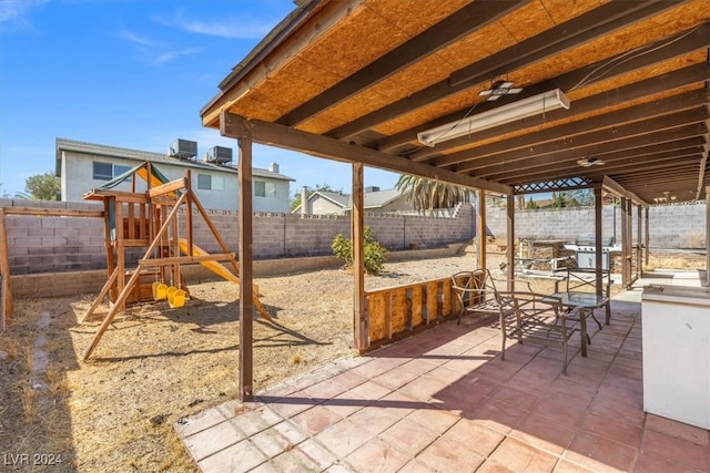 view of patio featuring a playground and ceiling fan