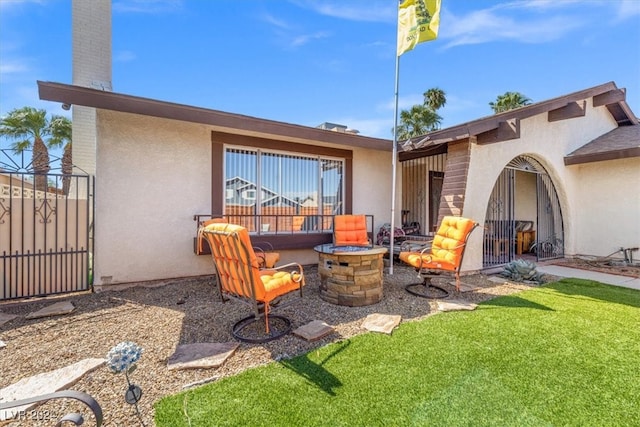 back of property featuring a yard and an outdoor fire pit