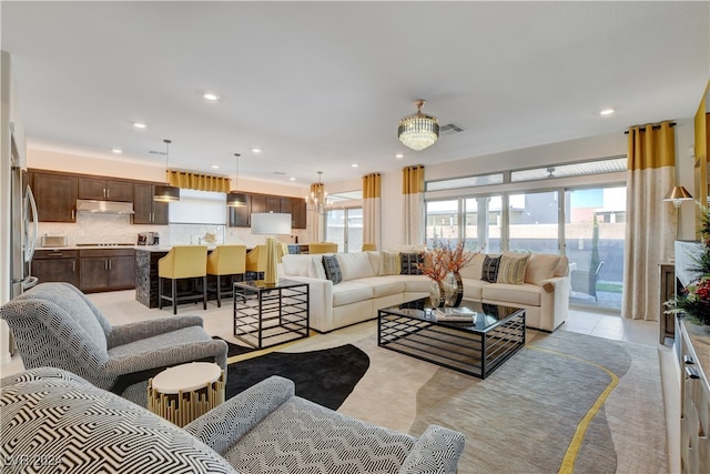 living room with a chandelier, light tile patterned floors, and a wealth of natural light