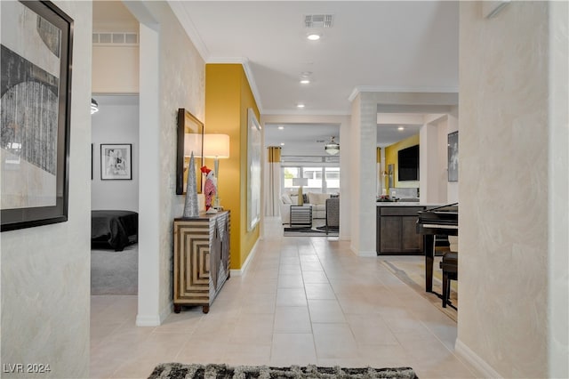 entrance foyer with light tile patterned floors and crown molding