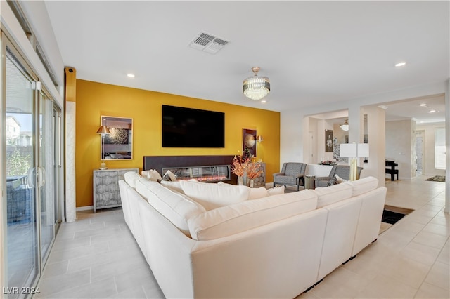 tiled living room with a notable chandelier