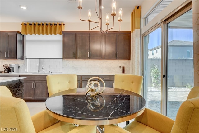 dining space with sink and a chandelier