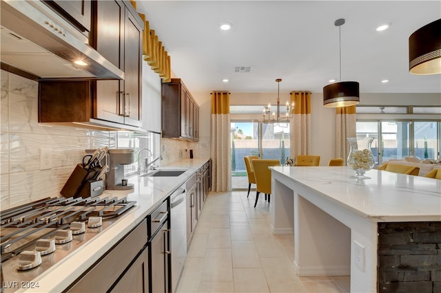 kitchen with hanging light fixtures, plenty of natural light, stainless steel appliances, and ventilation hood